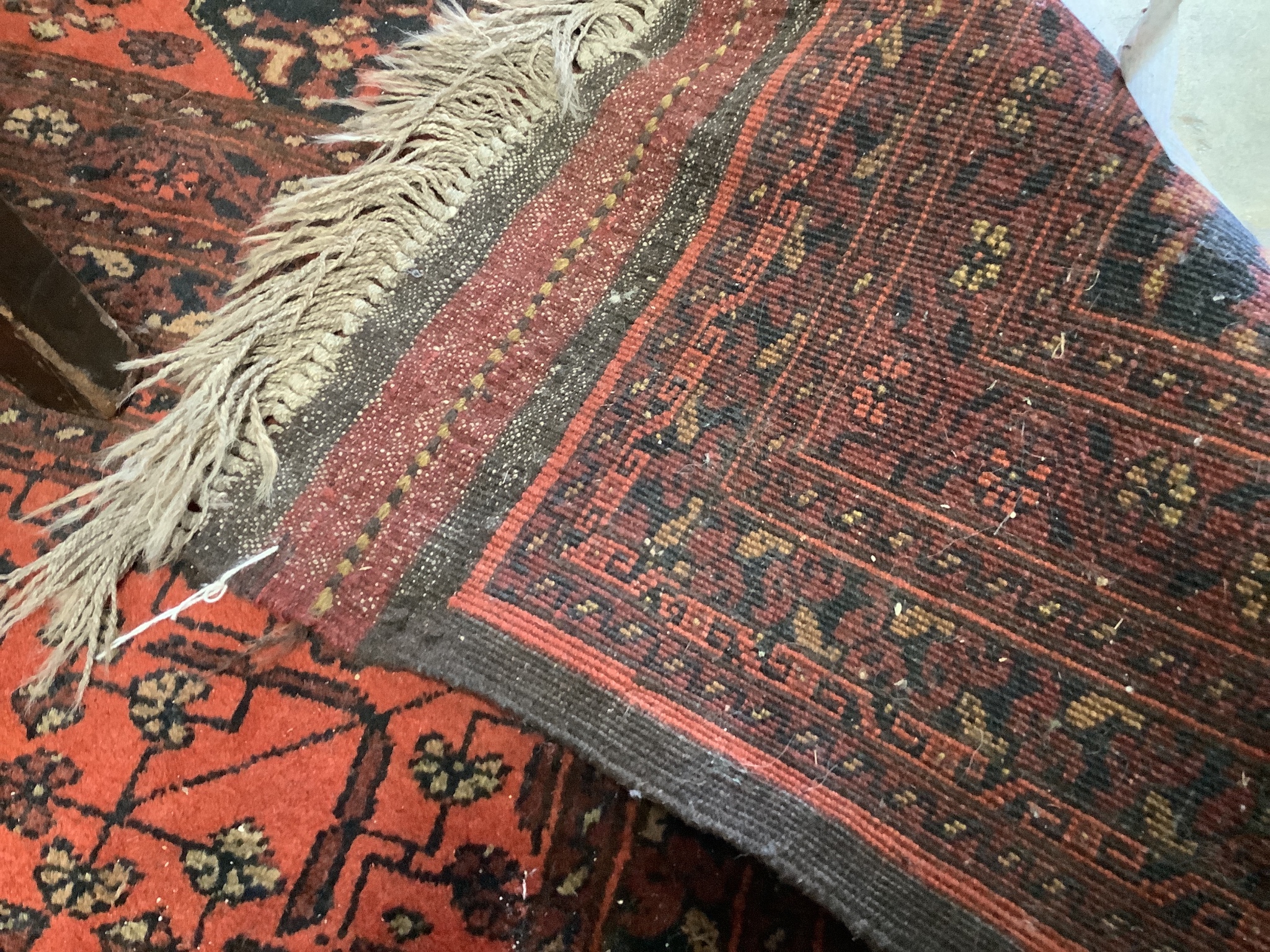 An Afghan red ground carpet, 360 x 260cm